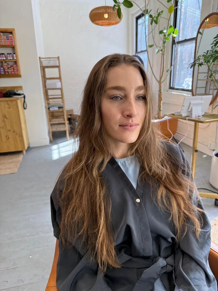 Long bronde hair before a dimensional brunette color service